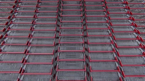 Red Shopping Carts Moving in Seamless Repetitive Rows