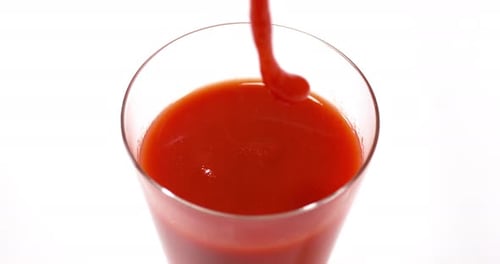 Tomatoe's Juice being poured into a Glass against White Background, Slow Motion 4K