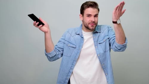 Frustrated Man Using a Smartphone Indoors