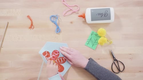 Flat lay. Little girl learning how to sew with her mother at the craft table.