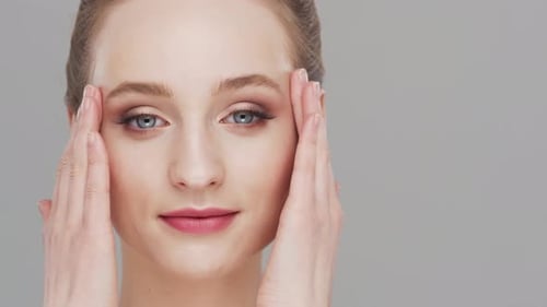 Studio portrait of young, beautiful and natural woman over grey background.