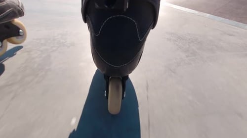 Roller Blades Rolling Through Skatepark on Sunny Day