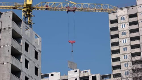 Large Construction Crane Sets Up the Wall on the Building
