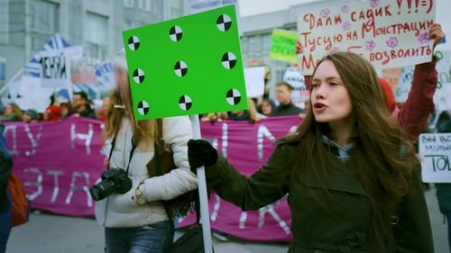 People Marching in City with Chroma Key Sign