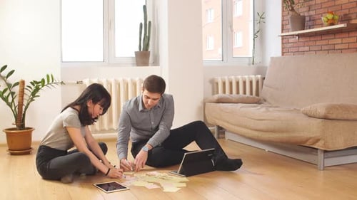Two Young Adults Brainstorming Together in Apartment