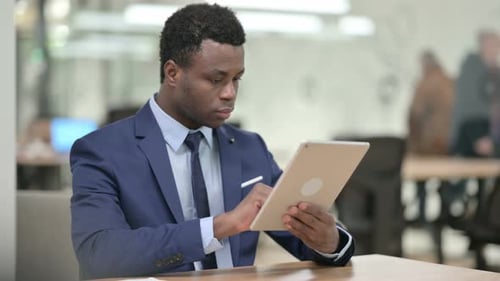 Afrikanischer Geschäftsmann nutzt Tablet bei der Arbeit