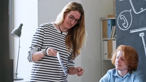 Woman Presents Charts to Colleagues in Office