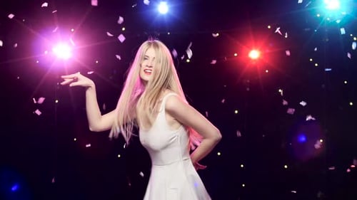 Woman Dancing in Confetti with Stage Lights