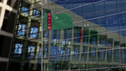 Waving Flag of Turkmenistan in Front of Modern Office Building