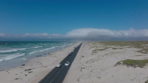 Forwards Descending Fly Above Busy Coastal Road