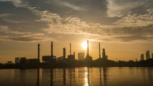 4k timelapse of 4k Oil refinery petrochemical plant timelapse at sunrise with reflection of river