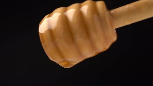 Footage Organic Honey Dripping From Wooden Honey Spoon on Black Background