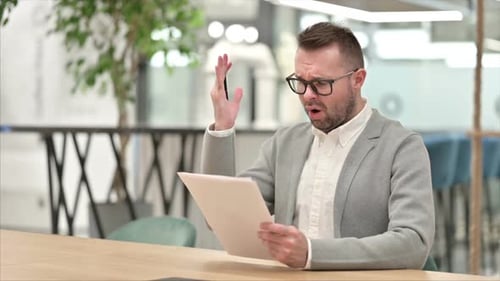 Man Reviews Document, Shows Frustration in Office