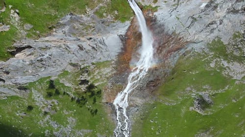 Aerial: drone flying over scenic waterfall and mountain stream on the italian Alps