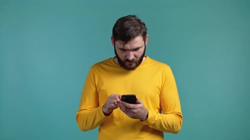 Man Using Smartphone Looks Surprised and Excited