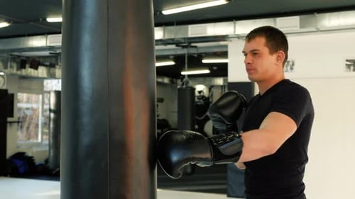 MMA Fighter Boxers Doing Some Training on a Punching Bag at a Gym Close Up Power Punch Kicks Macro