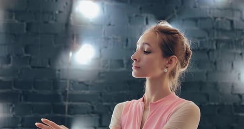 Elegant Woman Practices Ballet Arm Movements in Studio