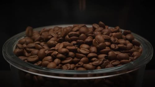 Pouring Roasted Coffee Beans Into Glass Bowl