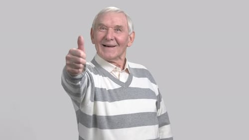 Un viejo haciendo un gesto con el pulgar hacia arriba.