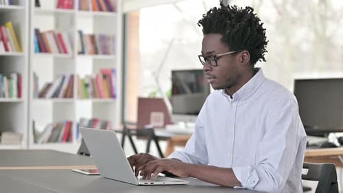 Man Giving Thumbs-Up While Working on Laptop