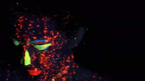 Portrait of a Girl in the Neon Light. Face Painted with Glow in the Dark Paint