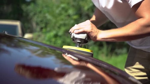 Man polishing a car in the city