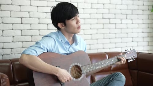 Man Playing Guitar and Singing Indoors