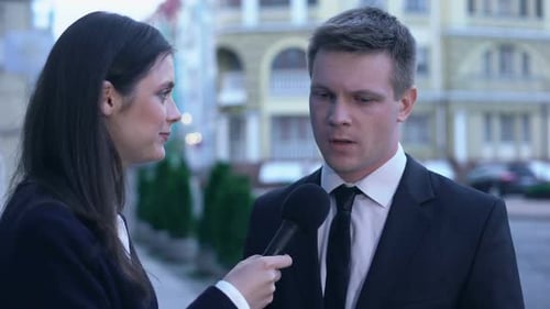 Reporter Interviewing Man in Suit on City Street