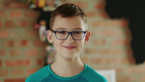 Portrait of a Smiling Boy in Eyeglasses and Green Tshirt