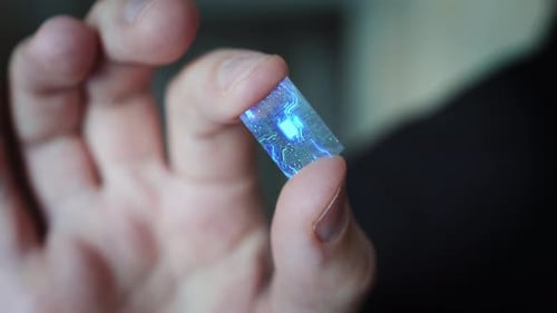 Close Up Macro Zoom Shot a Man Holds a Computer Processor With Holographic Luminous Chip Elements.