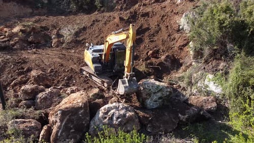 Crawler Bucket Rolls Boulder