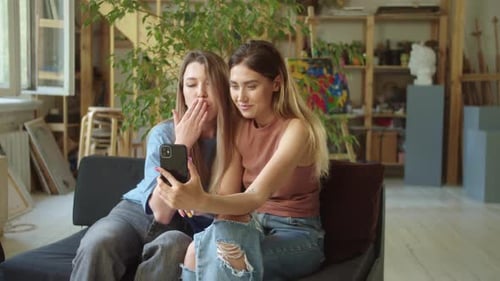 Zwei junge Lgbt-Damen sprechen mit ihren Freunden auf dem Videoanruf, den sie mit den Händen winken und