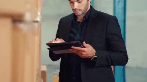 Factory Manager Using Tablet Computer in Warehouse or Factory