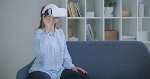 Woman Interacting With Virtual Reality Headset on Couch