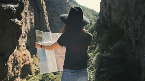 Woman Hiker with Map in Rocky Mountain Canyon