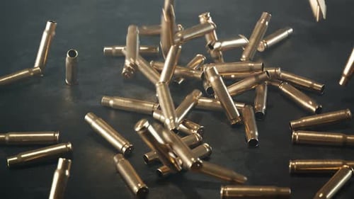 Brass Bullet Casings Falling on Dark Concrete Floor
