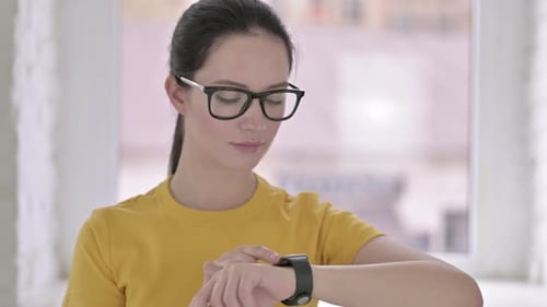 Young Woman Using Smartwatch Technology Indoors