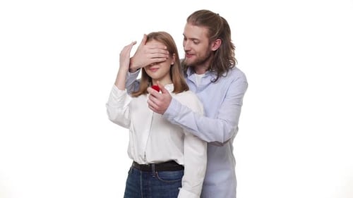 Man Surprising His Partner with Engagement Ring Over Isolated White Background