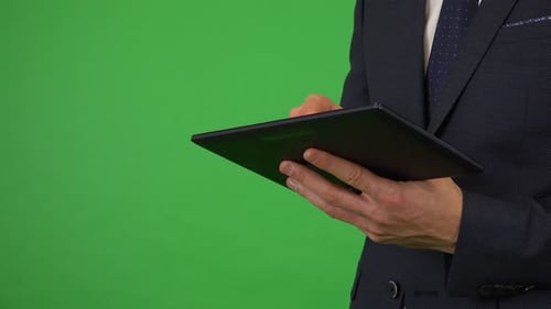 Ein Geschäftsmann arbeitet auf einem Tablet - Nahaufnahme - Green Screen Studio