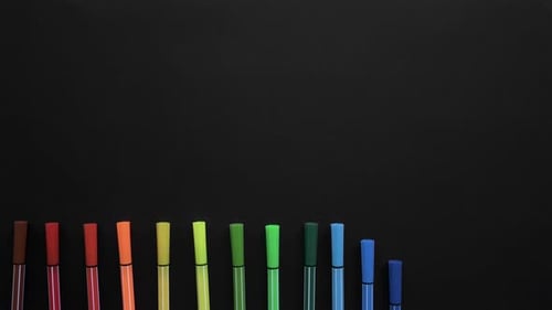School Markers of Different Colors Are Located on the Black Surface. Stop Motion Animation with