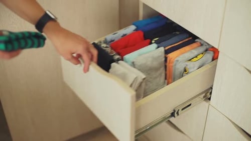 Woman Organizing Childrens Clothes in a Wardrobe