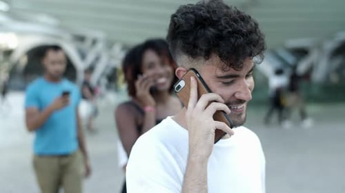 Man Smiles Talking on Phone in Urban Location