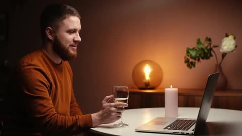 Man Celebrating Engagement Online with Wine and Laptop