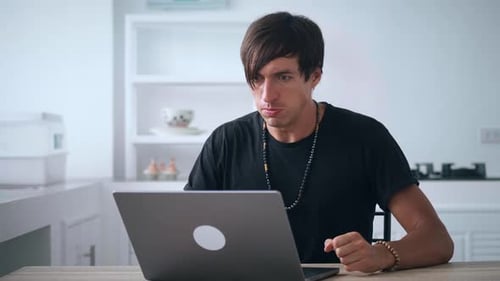 Frustrated Young Adult Using Laptop at Home