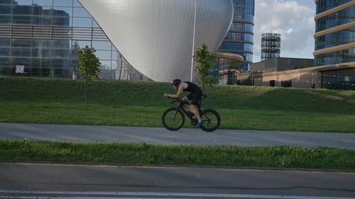 An Hardy Triathlete Rides a Bike Pro Cyclist Rides on a City Road Athlete Trains in an Urban