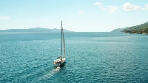 White Sailboat or Yacht Sails on the Sea with Blue Water