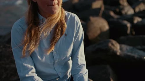 Photographer Sitting On Rock Holding Slr Camera