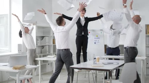 Ecstatic Colleagues Throwing Documents in Air