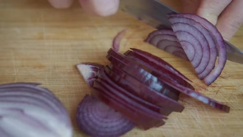 Red Onion Being Cut on Wooden Board