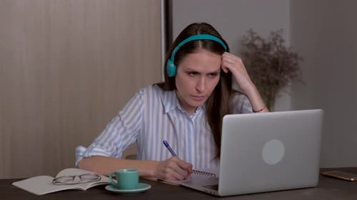 Woman Studying at Desk with Laptop and Headphones